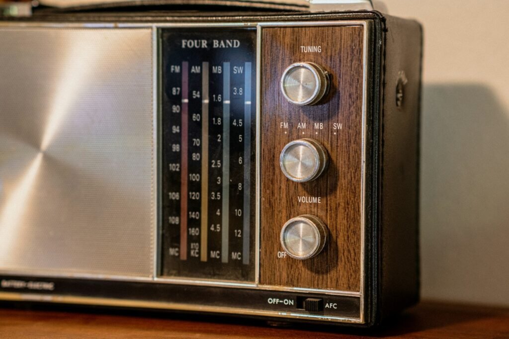 Radio antigua de dial con perillas sobre una mesa de madera