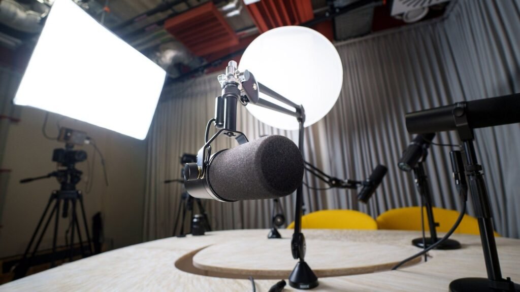 Estudio de podcast vacío con micrófonos, luces y cámara listos para grabar